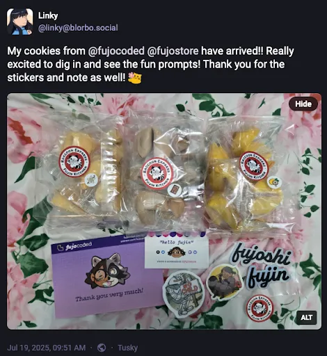 A Fediverse/Mastodon post by linky @ blorbo.social reading
My cookies from @ fujocoded @ fujostore have arrived!! Really excited to dig in
and see the fun prompts! Thank you for the stickers and note as well! (emoji of
a cute blob-shaped cat offering a flower)
A photo is attached. Linky’s alt text reads “Three bags of different flavored
fortune cookies. Alongside are two business cards and some stickers.”